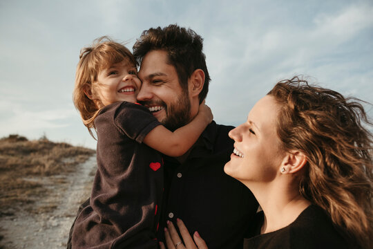 A young family with a little daughter on a walk.