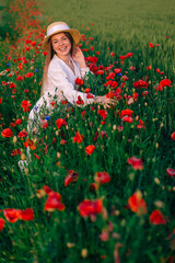 Naklejka na ściany i meble beautiful red poppies and girl in white dress and boater look at