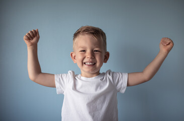 Portrait of happy little boy with arms up 