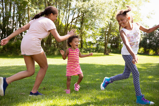 Sisters running and chasing each other in a game of tag