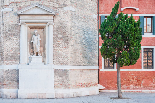 Two different facades of the buildings with the tree in the foreground
