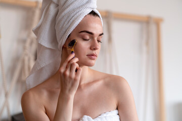 A Woman Using A Facial Roller