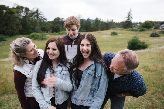 Laughing parents and teenagers together in field