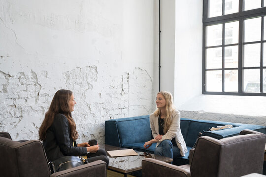 Friends Meeting In Cozy Coffee Shop