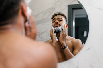 Cheerful black man applying shaving foam