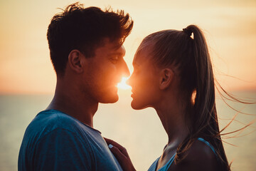 The romantic couple standing closely on the beautiful sunset background