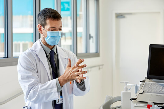 A doctor disinfecting hands