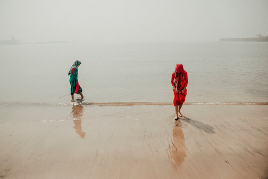 Two women in saris on the beach