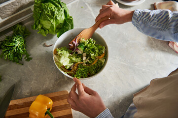 High angle view of a bowl with vegan salad with lettuce leaves and, tomatoes,and pepper.