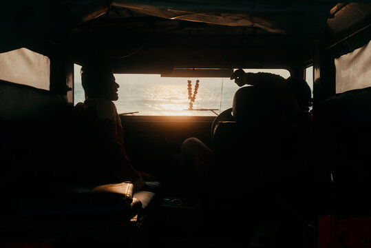 Two Men Rescuers Are Sitting In The Car On The Background Of The Ocean