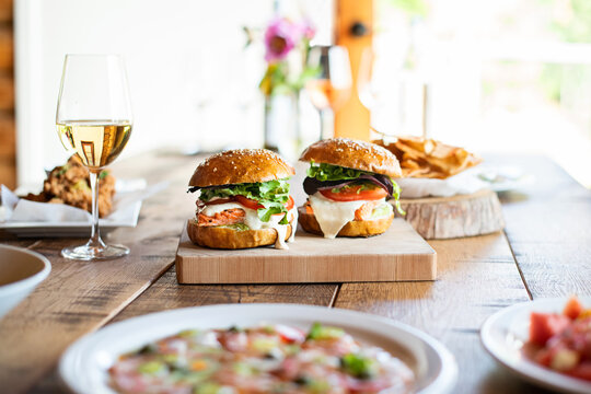 Wild salmon burgers on rustic wooden dinner table.