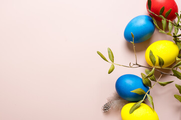Coloured decorated easter eggs on a pastel pink background