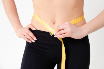 Fit woman measuring waist