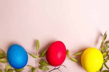 Coloured decorated easter eggs on a pastel pink background