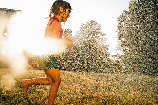 Girl running through hose.