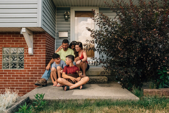 Family sitting together on front porch.