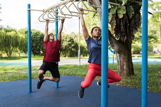 Couple working out using the monkey bars