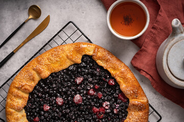 Homemade blueberry galette, tart on the table with tea . Top view. High quality photo