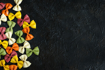 Vegetable pasta in different colors with copy space on black background