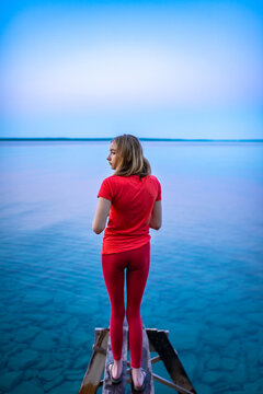 Teen Girl Relaxing at Dusk on Family Cottage on Dock at the Lake