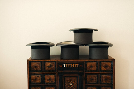 Grey High Hats Of Groom And Groomsmen On An Antique Closet