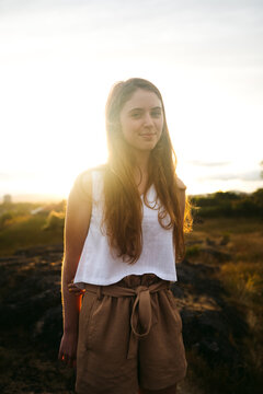 Young woman looking at the camera at sunset.