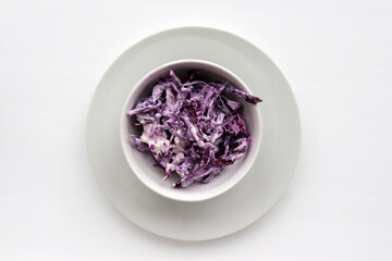 Obraz na płótnie Canvas Easy homecooked creamy coleslaw from red cabbage in a bowl on white table background. Top view, copy space. Fresh vegetable salad with mayonnaise dressing. Flat lay food. Healthy eating concept 