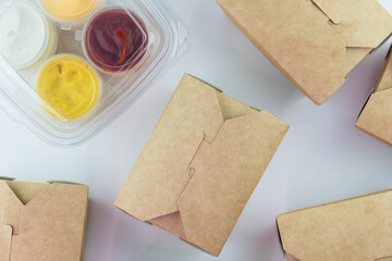 Food delivery service concept. Food in eco paper take away boxes with sauces. Meal diet plan for daily ready menu.