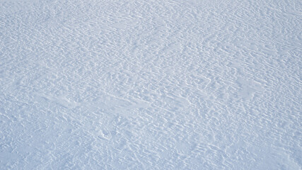 Natural snow texture, snow patterns from the wind, background.