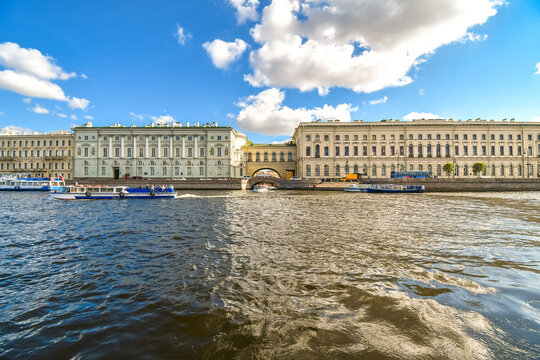 View of the Winter Canal and the arch bridge connecting the old and new sides of the Hermitage Museum from a boat along the Neva River in St. Petersburg, Russia.