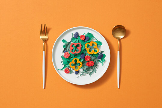 Isolated salad in a white bowl on a yellow background.
