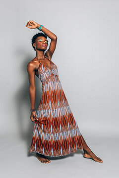 Black african woman posing in the studio with orange dress