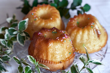 Unique Homemade Easter Muffins decorated with colorful sprinkles. Pound cake ready to be blessed on Holy Saturday. Decorated with Buxus and lesser periwinkle. Symbolic foods for Easter table in Poland