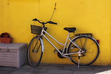 Fototapeta na wymiar Photo postcard with a bicycle standing against a yellow wall 