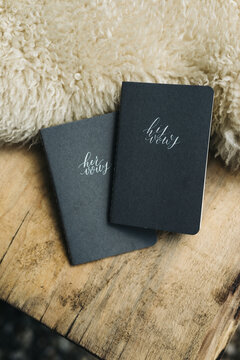 black booklets with his and her vows