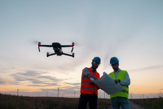 Construction workers inspecting wind turbines