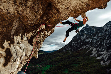 Young climber woman climbing on a overhanging wall
