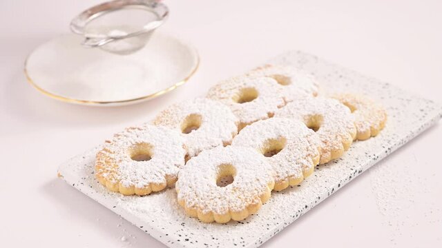 Canestrelli Sprinkle with powder, traditional Ligurian chamomile-shaped cookies with sugar on a white background. Holiday baked goods from the south of italy. 