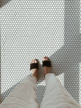 Minimal photo of woman standing on retro mosaic tile. Flat lay.