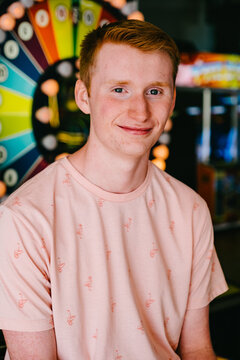 red headed teenage boy smiling at amusment park