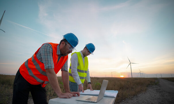 Engineers discussing on the windmill farm
