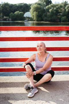 Senior woman is resting in the park after a run.