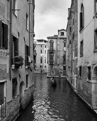 Venecia 3 de agosto de 2018. Fotografia en blanco y negro de una de las calles y canales de la ciudad. Gondolero llevando a turistas en su gondola