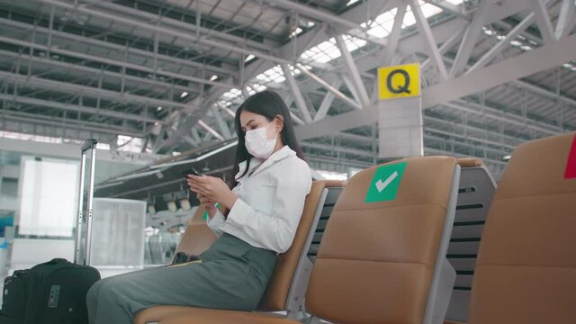 A business woman is wearing protective mask in International airport, travel under Covid-19 pandemic, safety travels, social distancing protocol, New normal travel concept