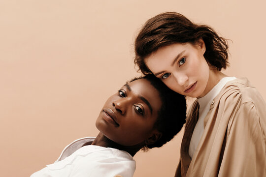 Young woman leaning on black girlfriend