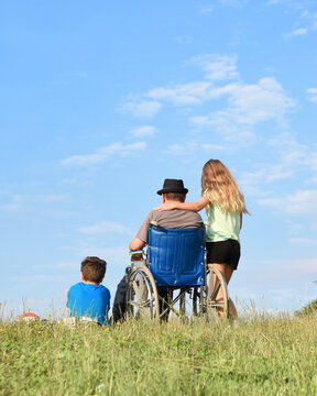 Father in Wheelchair with Children Outside