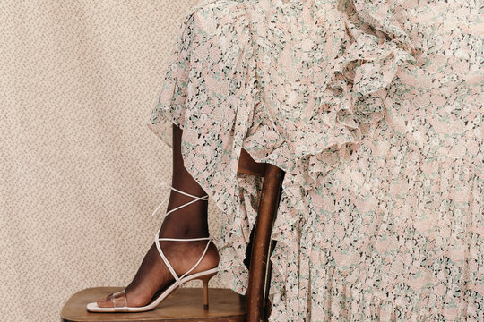 Crop black woman in sandal stepping on chair
