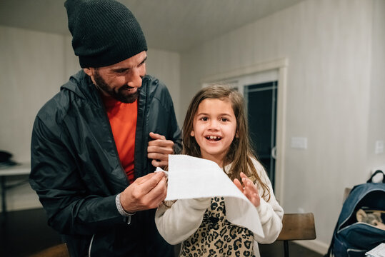 Dad pulling daughter's loose tooth.