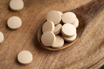 Brewer's yeast tablets on a spoon - nutritional supplement rich in vitamin B