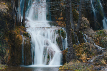 Waterfall in winter forest. 